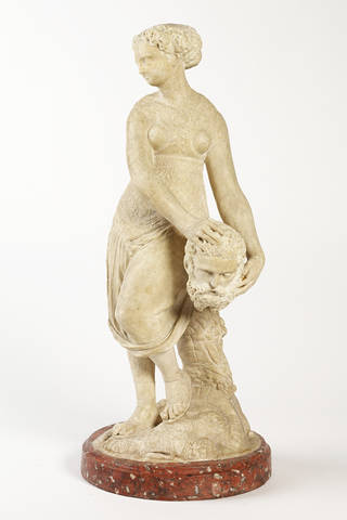 Creamy white stone statue of Judith, holding the head of Holofernes by her hip