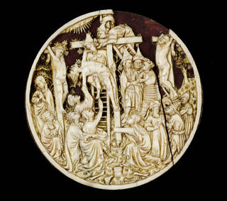 Circular white ivory carving depicting Jesus' descent from the cross