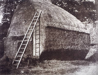 Black and white photograph of a large haystack