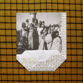 Orange and black checked background which frames a black and white photograph of women in Indian dress protesting with megaphones, a child-like smily face drawing and various bits of type and writing.