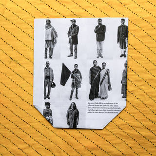 Bright yellow striped square of packaging material with a central photo of standing men and women in Indian dress