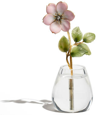 Pink enamel rose with green leaves standing in a clear rock crystal vase