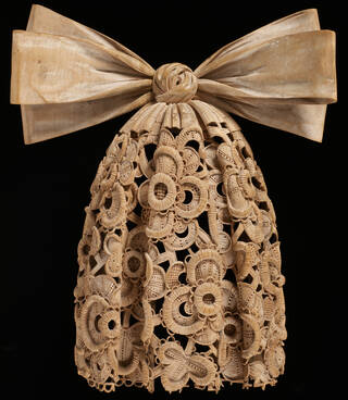 Intricately detailed lace cravat carved in lime wood with a large bow. 