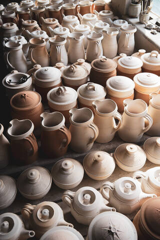 Lines of unfired pots in pale clay and terracotta colours