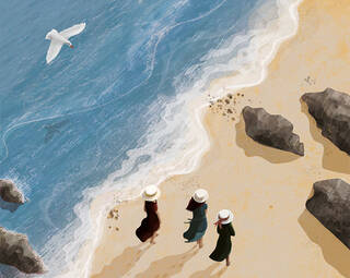 Three women walk along a beach, seen from above