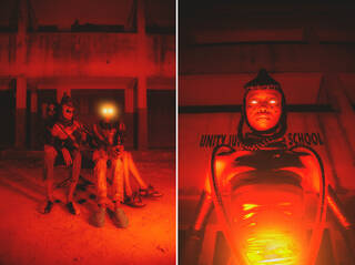 People dressed in futuristic clothing in an orange and red light with lights for eyes