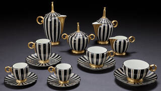 Black and white striped ceramic tea and coffee service on grey background