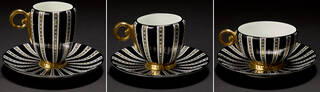 three cups and saucers with black and white stripes and gold details