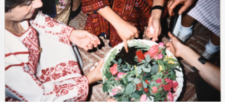 Several people dressed in Palestinian dress arranging flowers in a bowl