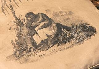 detail of a reticule with a print depicting an enslaved woman holding a baby