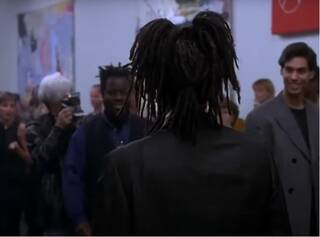 Image of a man with his back to the camera wearing a dark suit