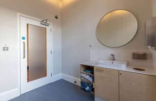 A view of one of the quiet rooms facing the door. A Qibla is printed in black on the wall just off the right top corner of the door.