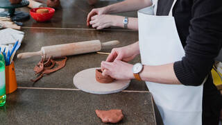 person working with clay with their hands