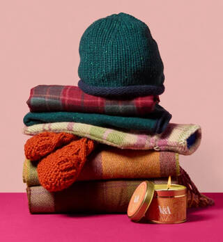 Pile of woollen items including gloves, scarves, hot water bottles and knits